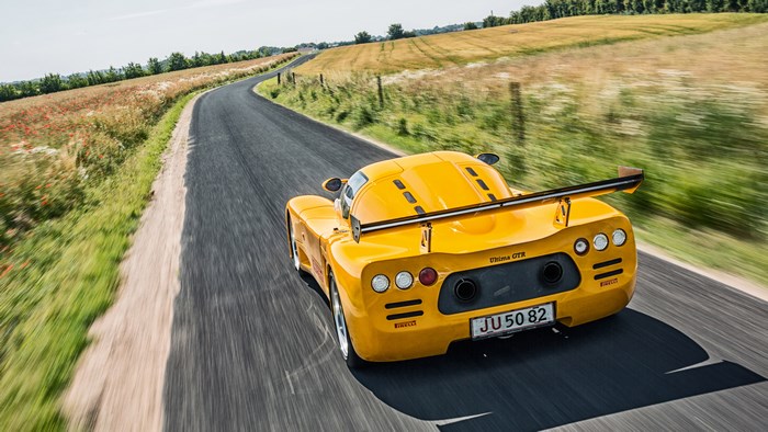 Yellow Ultima GTR driving on a country road