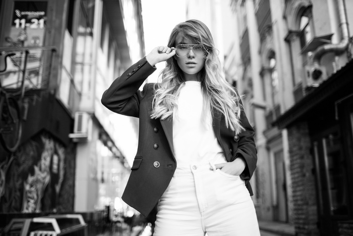 Woman wearing glasses and a blazer in a city