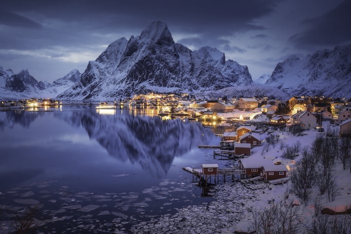 Snowy Lofoten village by a lake at night
