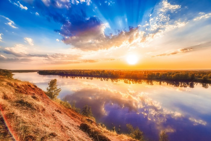 Sunset over a wide river with reflections