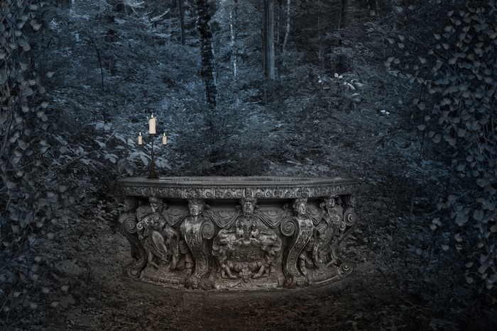 Gothic stone table with candelabra in forest