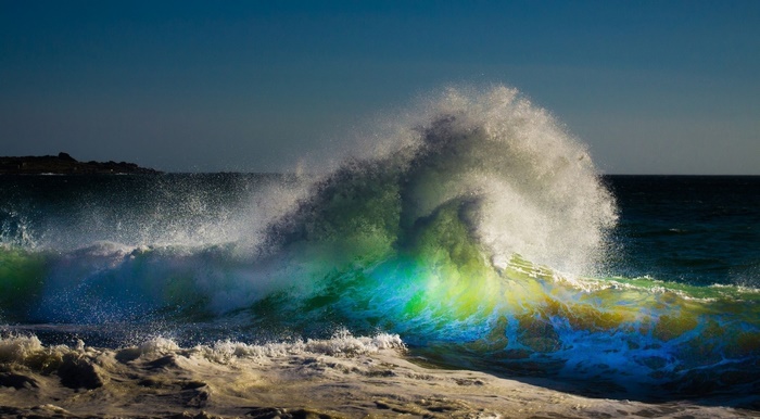 Crashing ocean wave with colorful light
