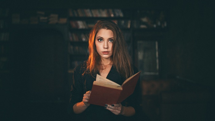 Woman reading a book in a library