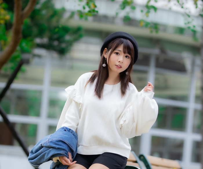 Asian woman wearing a beret and white sweater