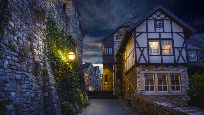 Stone building alleyway at night with stars