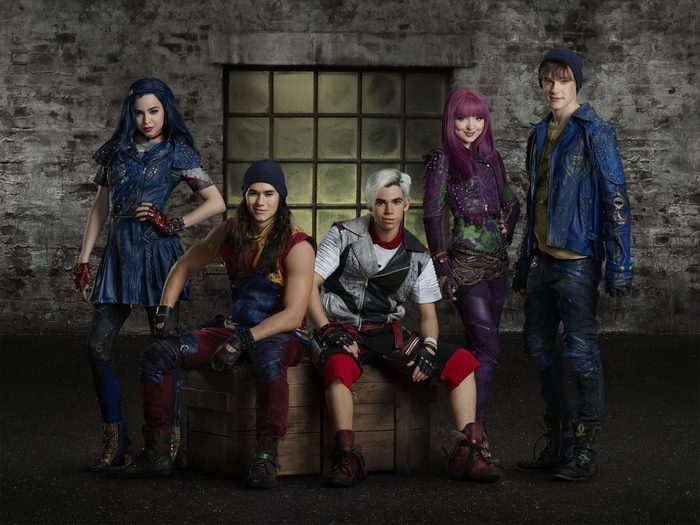 Descendants characters posing in front of a brick wall