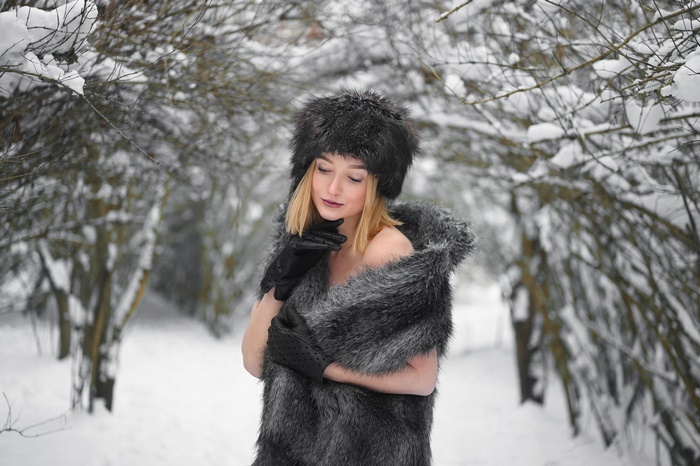 Woman in fur hat and stole in snowy forest