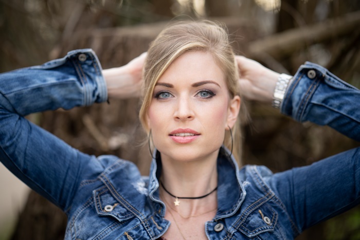 Woman with blonde hair and blue eyes wearing denim jacket