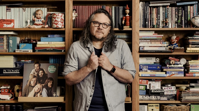 Jeff Tweedy in front of bookshelves