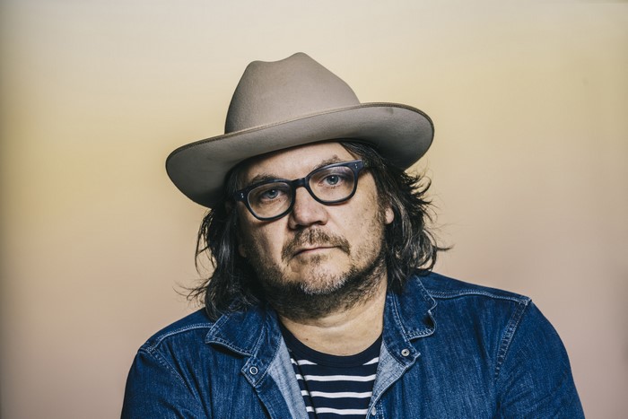 Jeff Tweedy wearing a hat and glasses