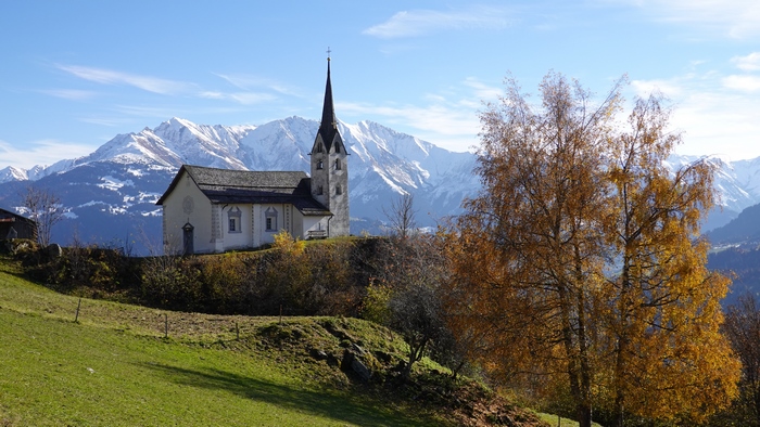 Church on a hill with snow-capped mountains