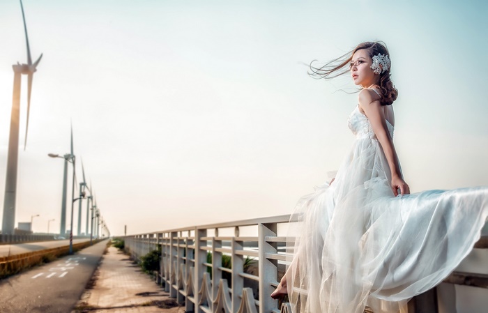 Woman in white dress with wind turbines