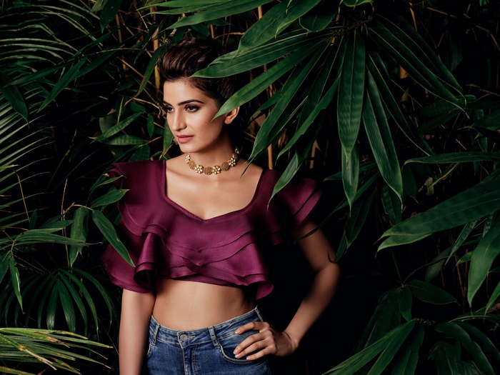 Woman in a purple crop top and jeans