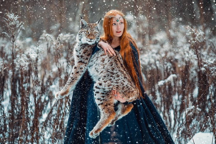 Woman holding a lynx in the snow