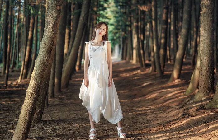 Woman in white dress in a forest