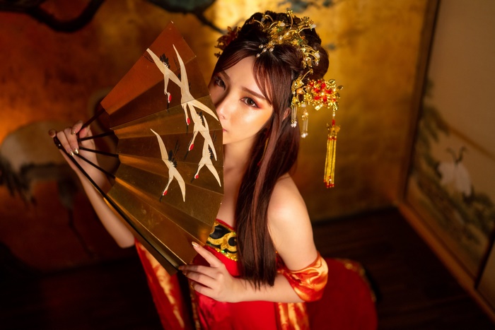 Woman in traditional Japanese attire holding a fan