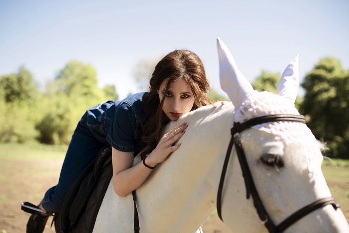 Woman lying on a white horse