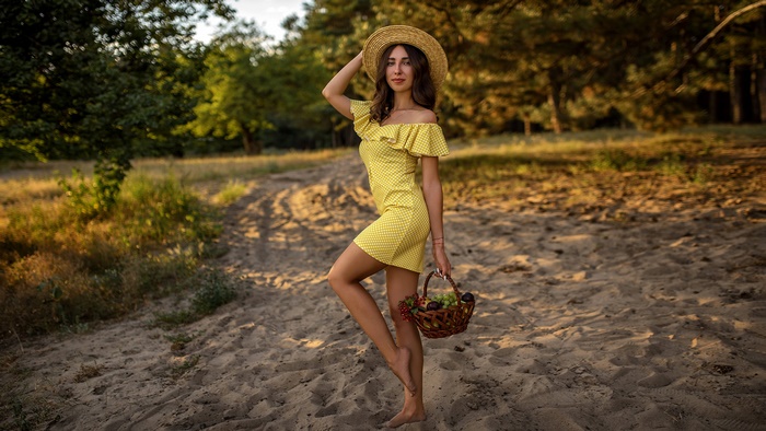 Woman in yellow dress holding a basket of fruit