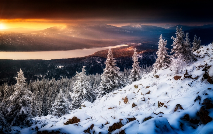 Snowy mountain landscape with lake and sunset