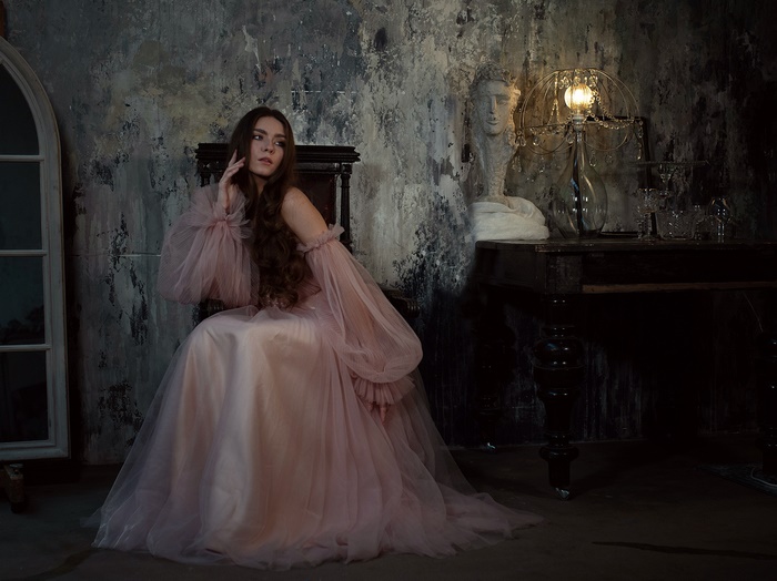 Woman in a pink dress sitting in a chair