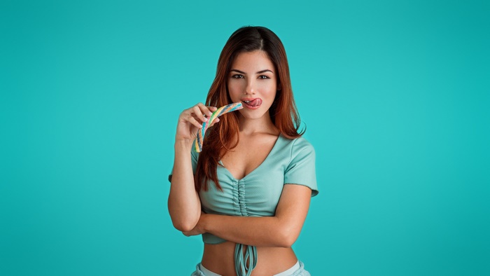 Woman licking a colorful candy stick