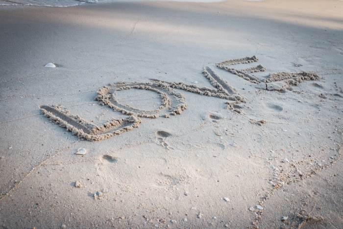Love written in sand on a beach