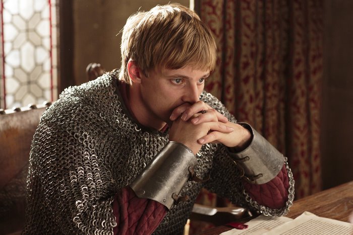 Arthur from Merlin sitting at a table