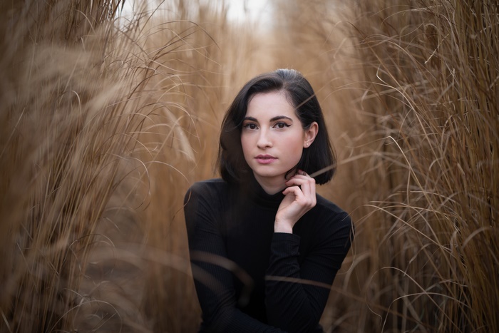 Woman with short black hair in tall grass
