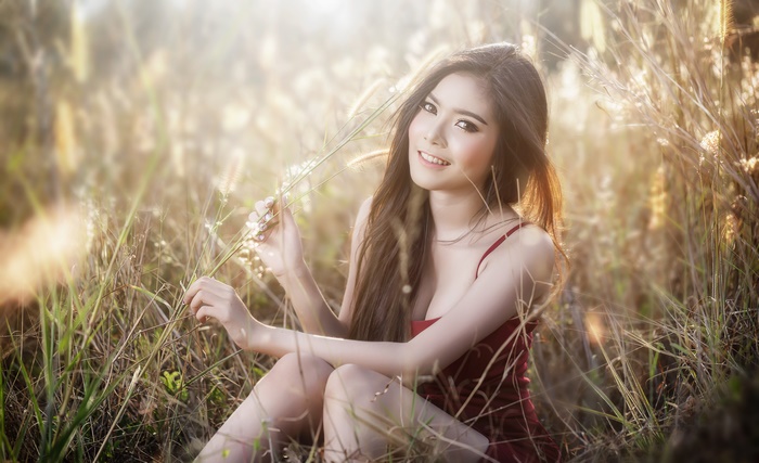 Asian Woman with Long Brunette Hair Smiling in Field