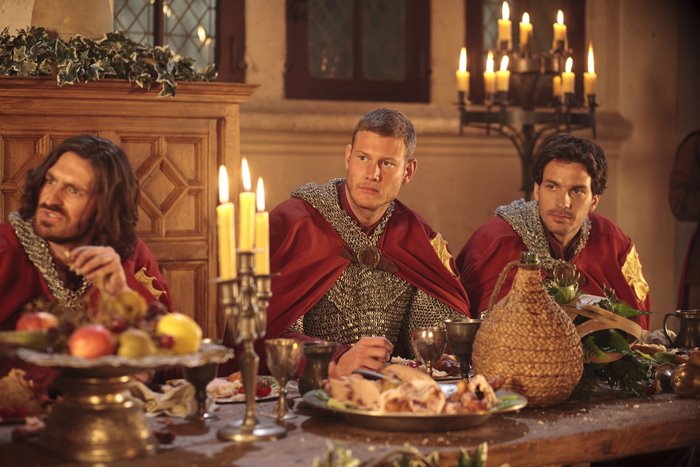 Men in medieval attire at a feast