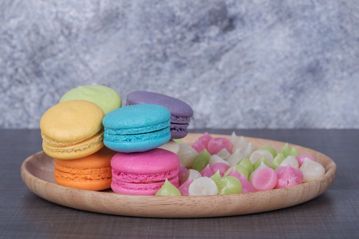 Colorful Macarons and Candies on a Wooden Plate