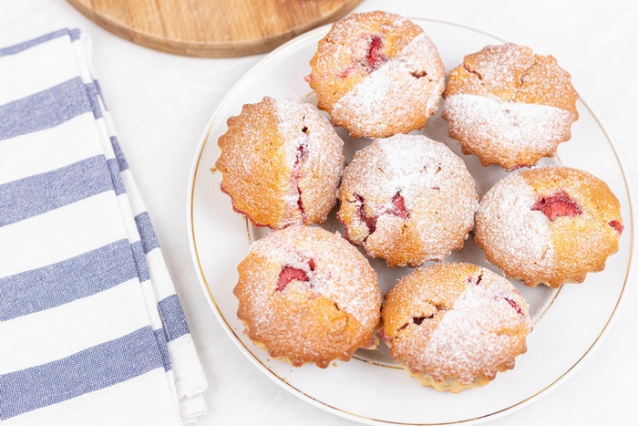Strawberry muffins dusted with powdered sugar on a plate