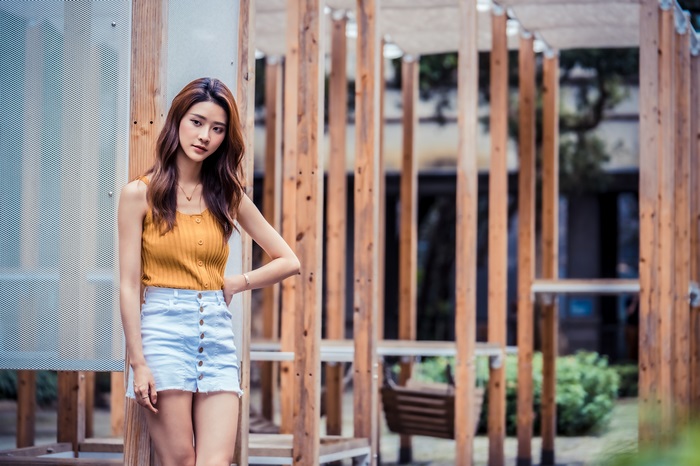 Asian woman in yellow top and denim skirt