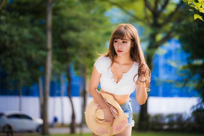 Asian woman with long hair holding a hat