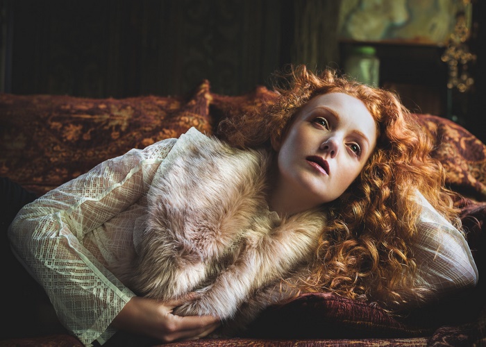 Redhead woman with curly hair wearing a fur stole