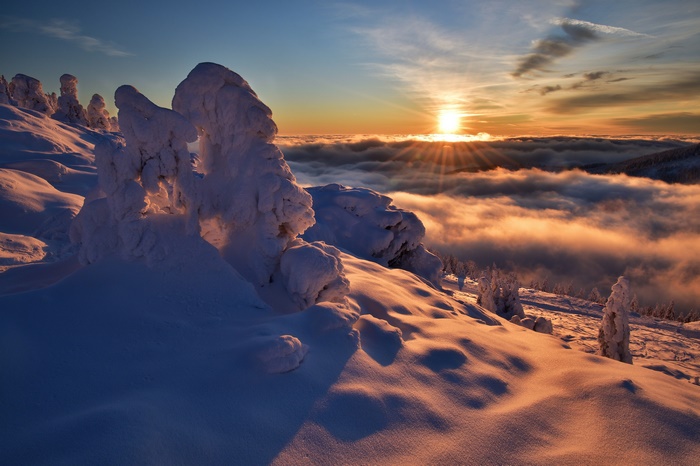 Sunrise over snowy mountains with clouds