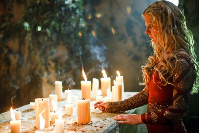 Morgause preparing a spell with candles