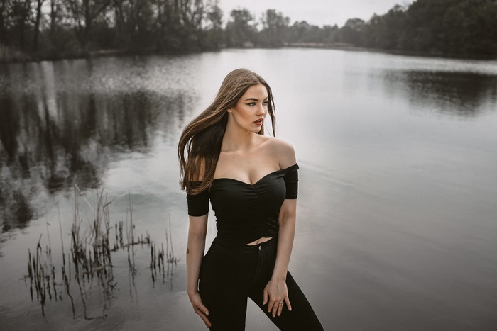 Woman with long brown hair by a lake