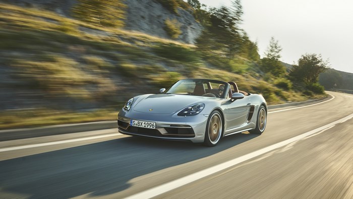Silver Porsche Boxster driving on a winding road