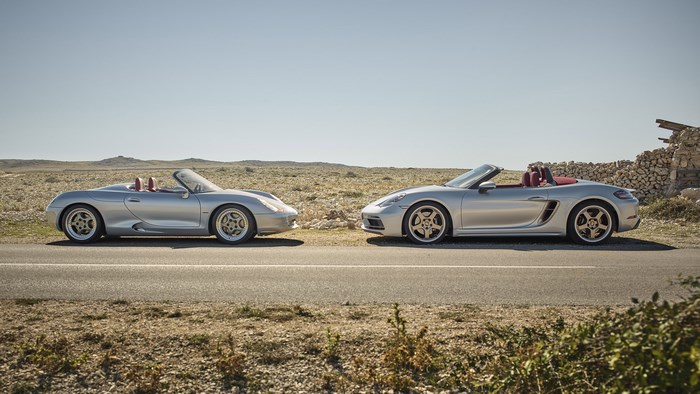 Two silver Porsche Boxster cars on a road