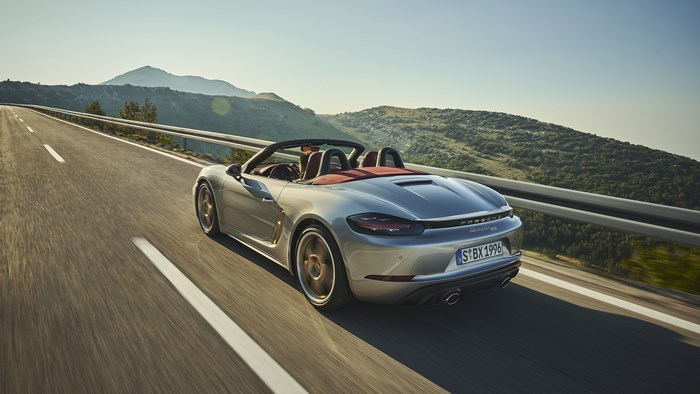 Silver Porsche Boxster driving on a mountain road