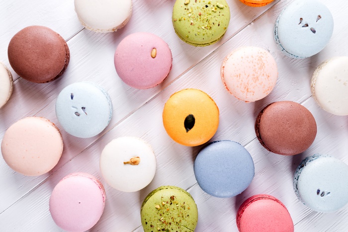 Assortment of colorful macarons on a white wooden surface