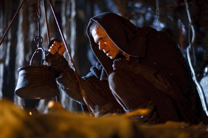 Jonas from Merlin cooking in a cave