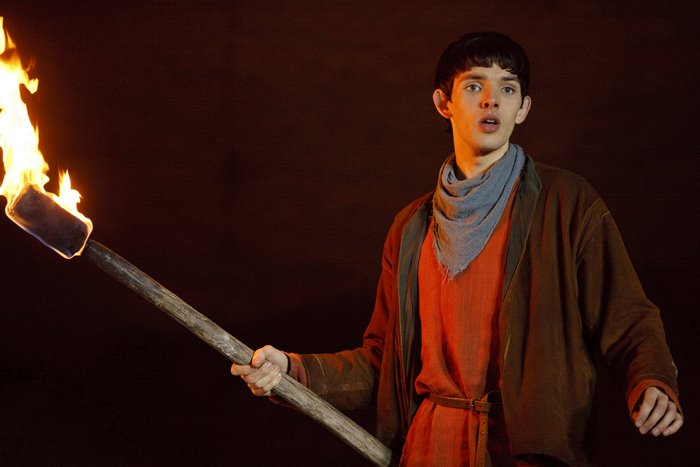 Merlin from Merlin holding a torch