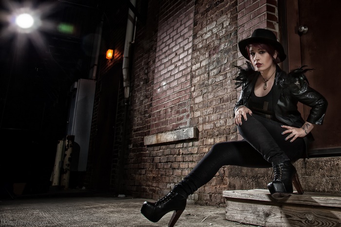 Woman in Hat and Leather Jacket in Alley