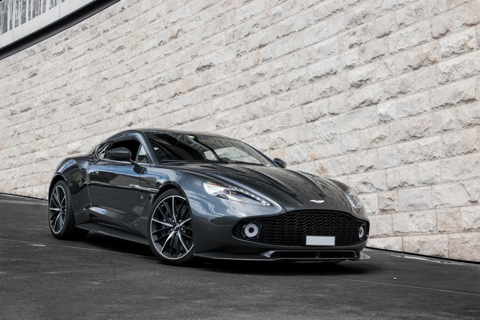 Aston Martin Vanquish parked by a stone wall