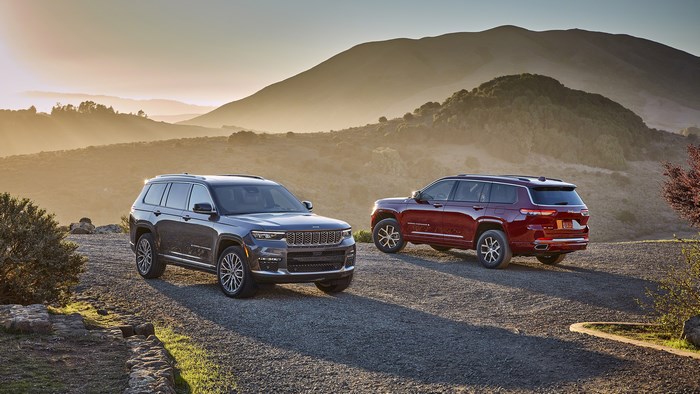 Two Jeep Grand Cherokee L SUVs on a mountain road