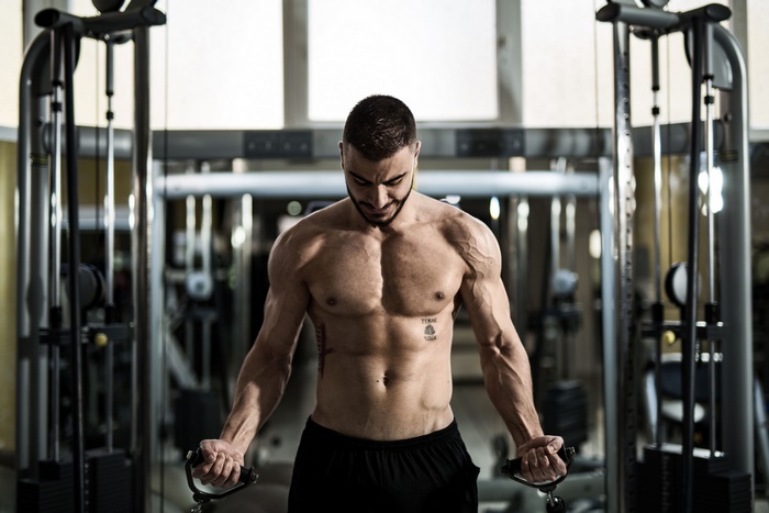 Man exercising with cable machine in gym