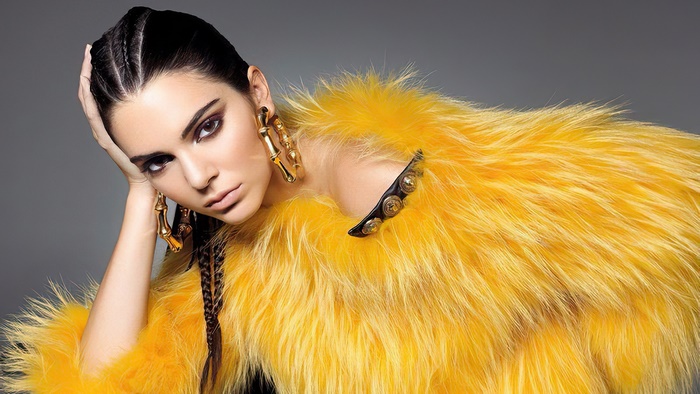 Kendall Jenner in yellow fur coat with gold earrings