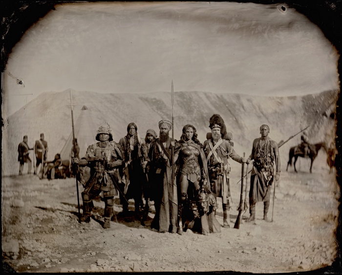 Wonder Woman and diverse group of warriors in desert landscape